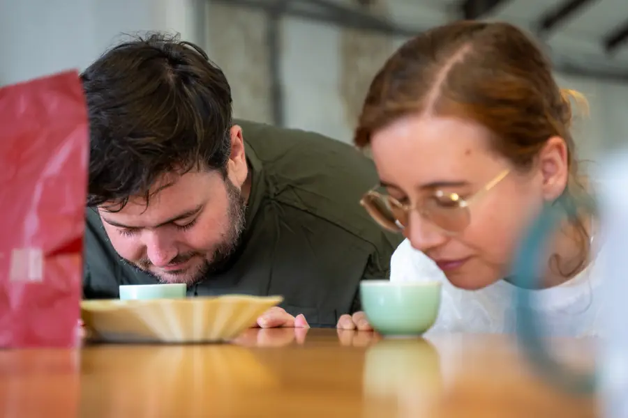 Zwei Personen riechen an Kaffeetassen